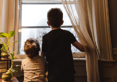 Dos menores miran por la ventana